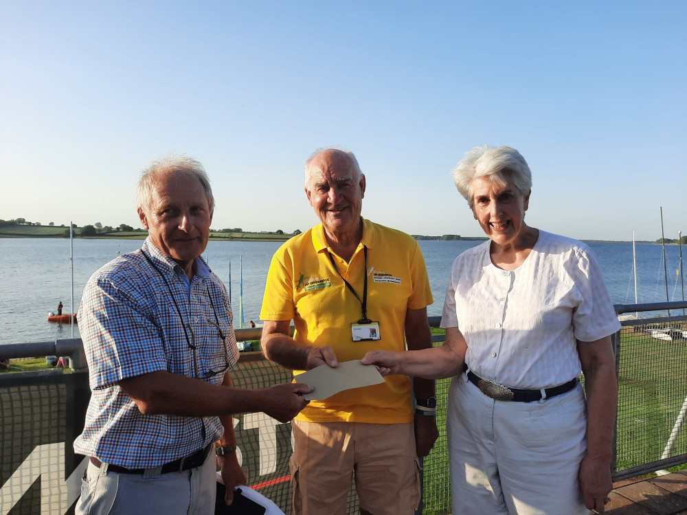 Dave Cadman handing over a cheque to John Batty (Air Ambulance) and Sarah Forsyth (Sailability) at Rutland Sailing Club