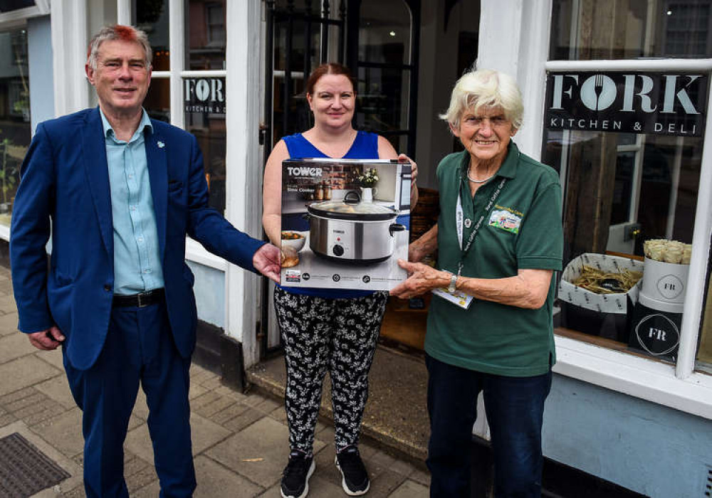 Cllr Derek Davis, Babergh's cabinet member for Communities presents a slow-cooker to an attendee of the Hadleigh cookery project at the Fork, along with a representative from the Rural Coffee Caravan (Photo credit: Gregg Brown and Babergh)