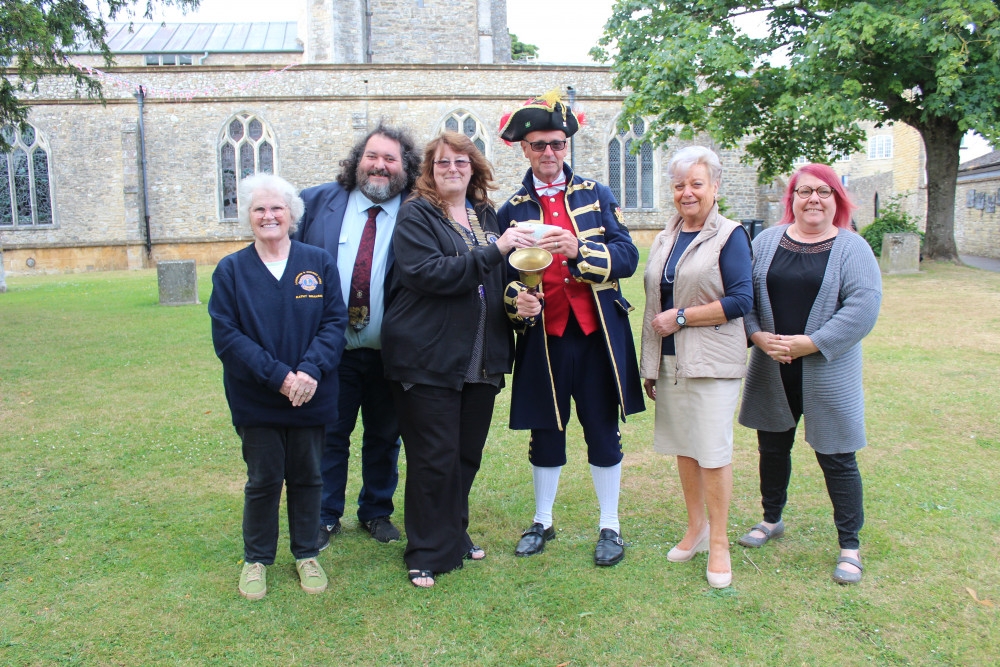 Axminster & District Lions Club president Beverly Love and members present a cheque to town crier Nick Goodwin