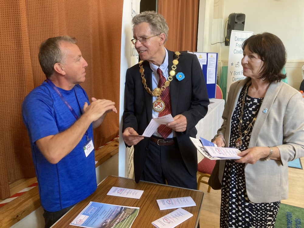 A representative of Ty Hapus explains the work Ty Hapus to the mayor and mayoress at the Dementia Friendly Cowbridge Open Day. (Image credit: Cllr John Andrew)