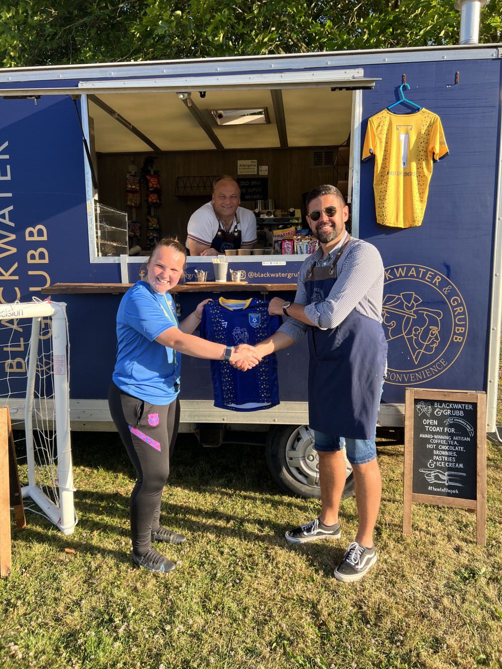 Winsford U8's manager, Abbey (left) receives the first kit from new sponsors Blackwater & Grubb. Alex (right), Peter (centre).