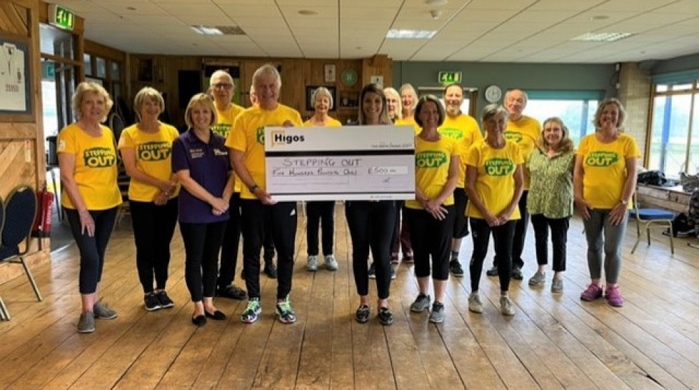 Elaine Street and Alex Hook of Higos Insurance Services, Bridport presenting a cheque to Richard Walsh and Jo Perfect and members of Stepping Out