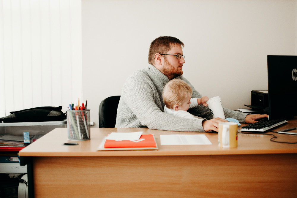 Man working from home with child (https://www.pexels.com)