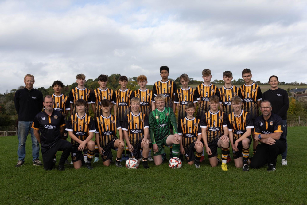 Axminster Town Under 16s have new sponsored shirts, courtesy of Millers Farm Shop. James and Olivia Miller are pictured with the squad at a recent game Axminster Town Under 16s have new sponsored shirts, courtesy of Millers Farm Shop. James and Olivia Miller are pictured with the squad at a recent game