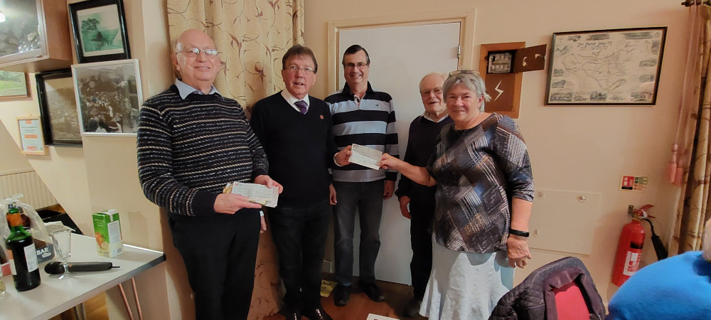 Mervyn Symes, vice-chair of Axminster Care Service (second from left) receives a donation from Dalwood Fair Committee