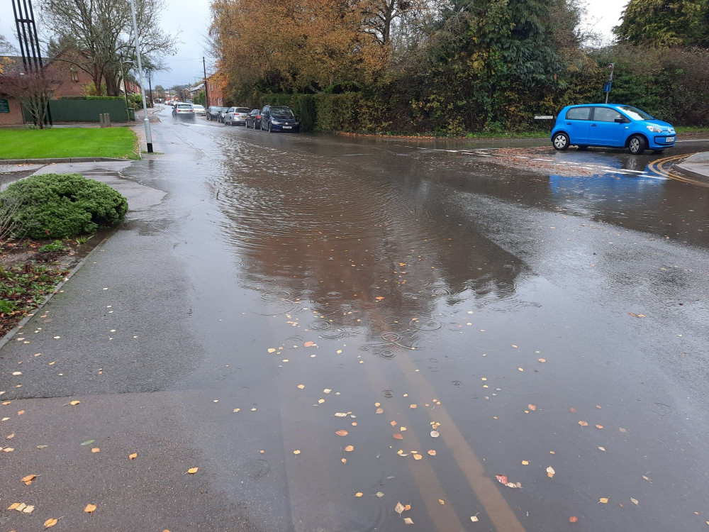 The flood covers most of the road and some of the pavement