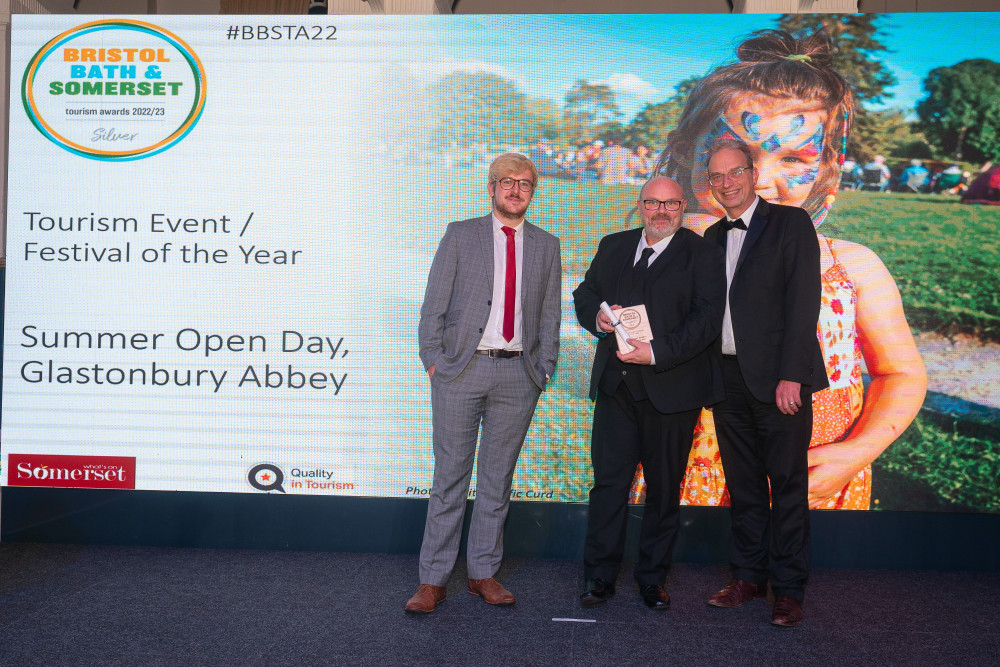   Glastonbury Abbey’s Tolly Snell (left) and Brad Lister (centre) collecting the silver award for their Summer Open Day at the Bristol, Bath and Somerset Tourism Awards