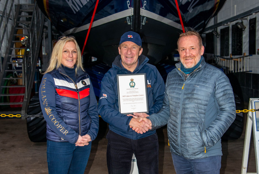 Chair of Exmouth RNLI Fundrasing Team, Des White, presents Malcolm and Kirsty Sansom with their prestigious award. Credit : John Thorogood / RNLI