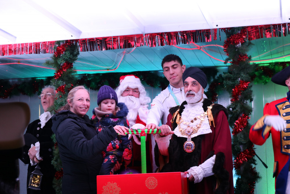 Flo and her mum were invited on to the stage at the Warwick Victorian Evening to switch the lights on with the Mayor of Warwick, Cllr Parminder Singh Birdi, and Commonwealth Games gold medallist Lewis Williams (image via WDC)