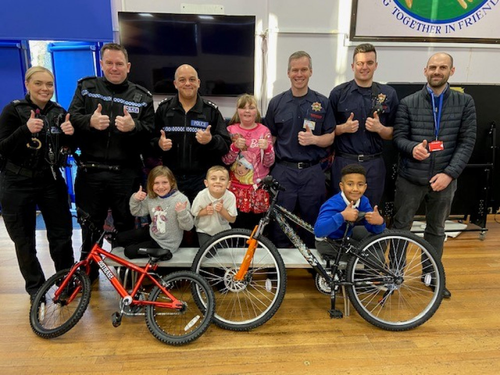 Leicestershire Police, Leicestershire Fire and Rescue Service and Chairman of the Safer North West Leicestershire Partnership present Warren Hills pupils with their bikes and Conkers passes and (below) the winning Christmas card designs by Eliko (8) and Grace (6)