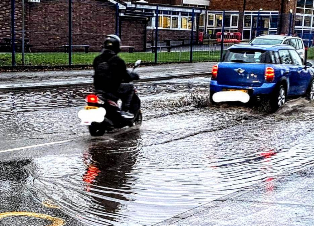 The flooding outside St Thomas More Catholic High School and St Mary's Catholic Primary School spreads across both sides of the road (Crewe Nub News).