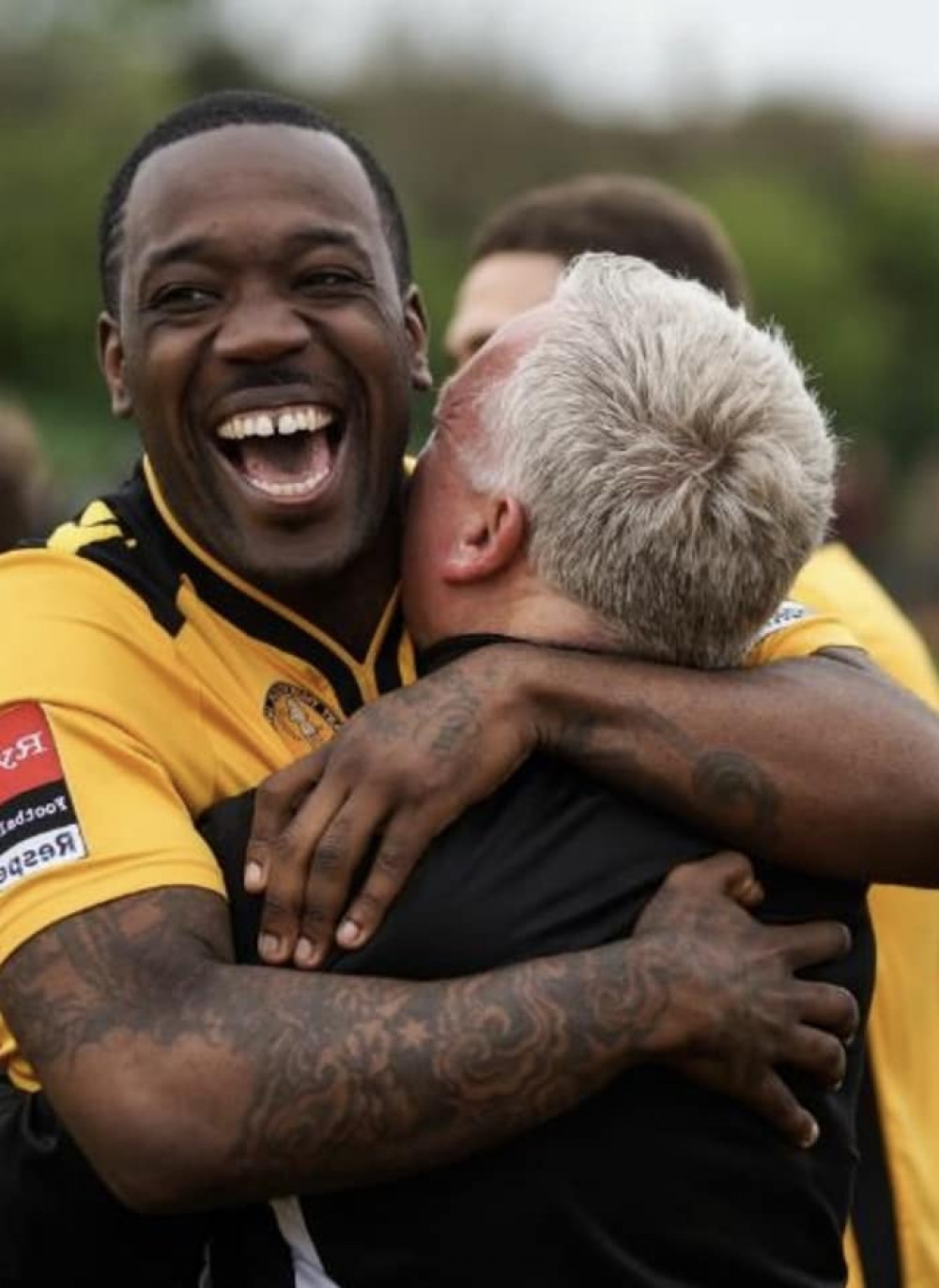 James Walker is hugged by East Thurrock United manager John Coventry after helping the Rocks win promotion. 