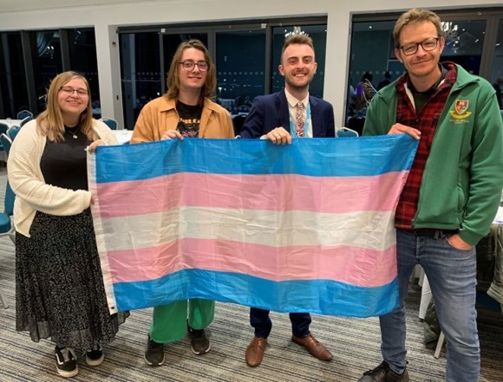 Cllr Joe Whibley (right) and Cllr Jake Bonetta (second from right) holding transgender flag (EDDC)