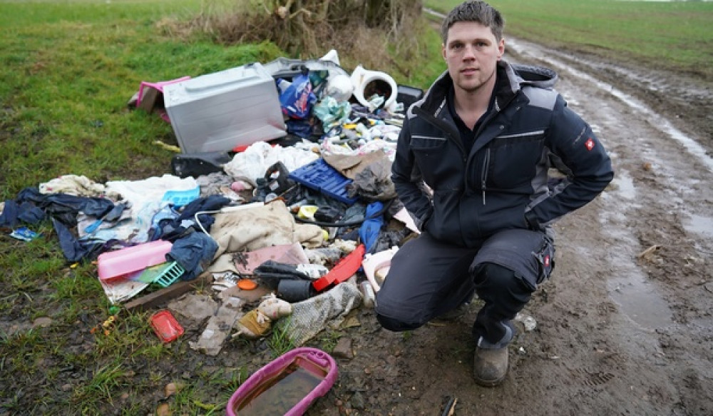Will Oliver with the pile of rubbish at his farm. Photo: SWNS Will Oliver with the pile of rubbish at his farm. Photo: SWNS