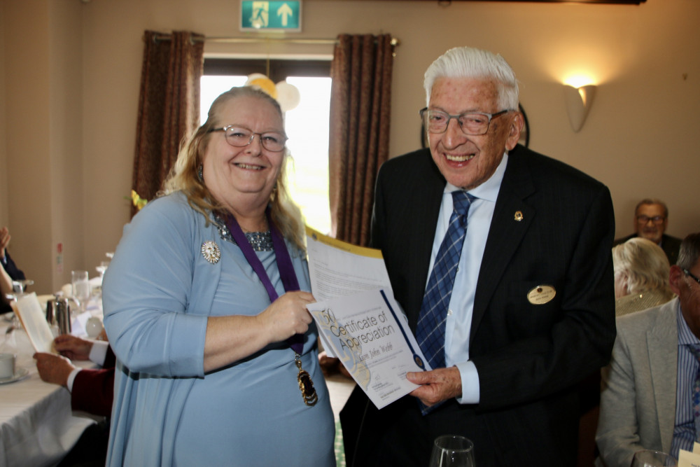 Lion John Webb receives his 50 year certificate from district governor Lesley Chudley