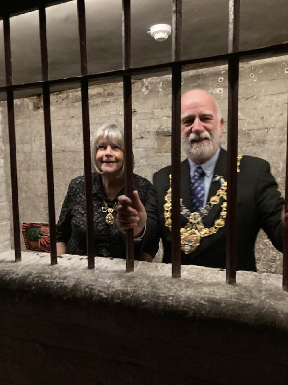 The Mayor of Bridport, Cllr Ian Bark, and mayoress Anne Bark, behind bars at Shire Hall Museum (photo credit: Discover Dorchester/Dorchester Town Council)