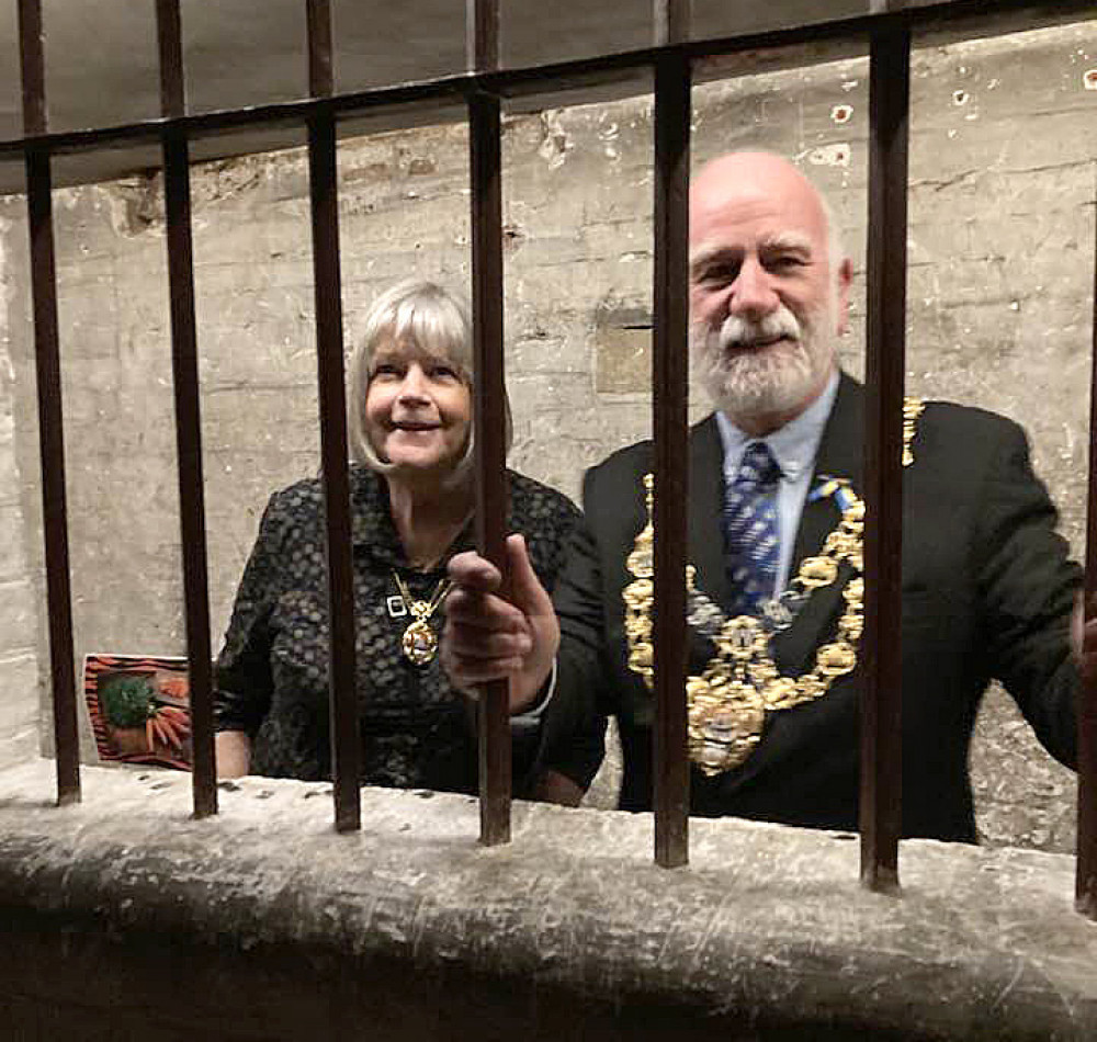 The Mayor of Bridport, Cllr Ian Bark, and mayoress Anne Bark, behind bars at Shire Hall Museum (photo credit: Discover Dorchester/Dorchester Town Council)