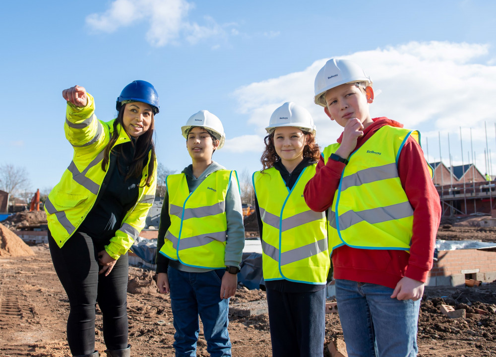 Bellway Assistant Site Manager Amy Hamilton with a group of pupils from Cubbington CofE Primary School at Bellway’s Hazelwood development in the village.