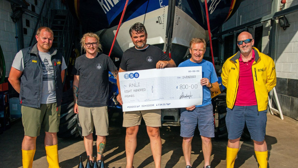 Oliver Bainbridge, centre, presents cheque to Exmouth RNLI (John Thorogood/ RNLI)