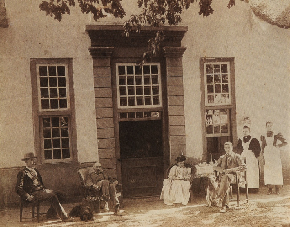 John X Merriman was a British politician who became Prime Minister of the previous Cape Colony in 1908. Here he is seen sitting on the stoep with his wife, friends, servants and dogs.