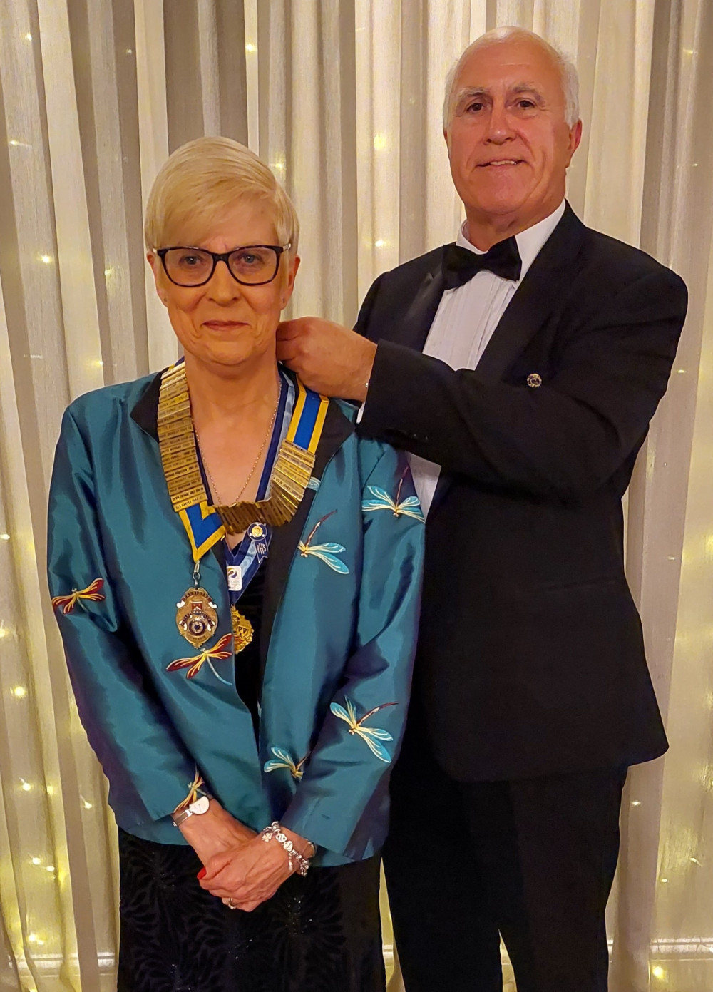 Outgoing President Huw Davies presented the President's regalia to incoming President Past District Governor (D1210) Carol Hallewell. Outgoing President Huw Davies presented the President's regalia to incoming President Past District Governor (D1210) Carol Hallewell.
