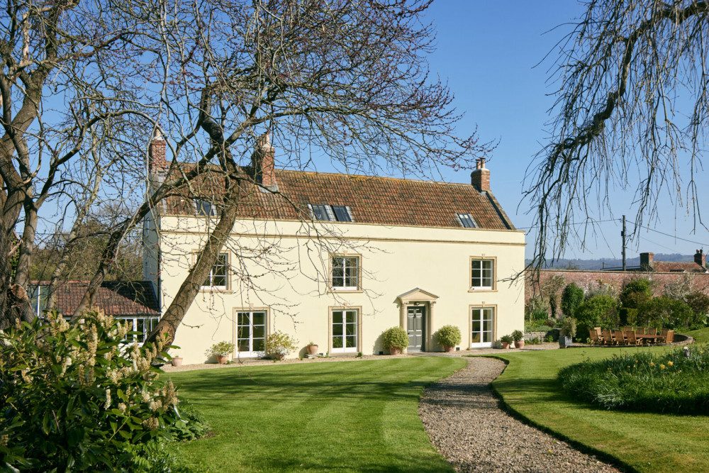 With approximately 4,530 square feet of interior space, the house boasts a series of reception rooms, six bedrooms, and a separate one-bedroom cottage.