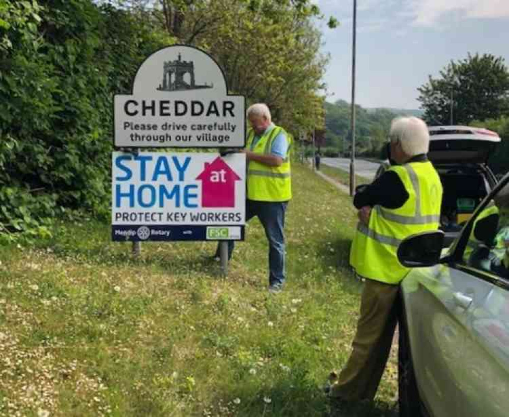 Mendip Rotarians fixing Covid-19 warning signs in Cheddar