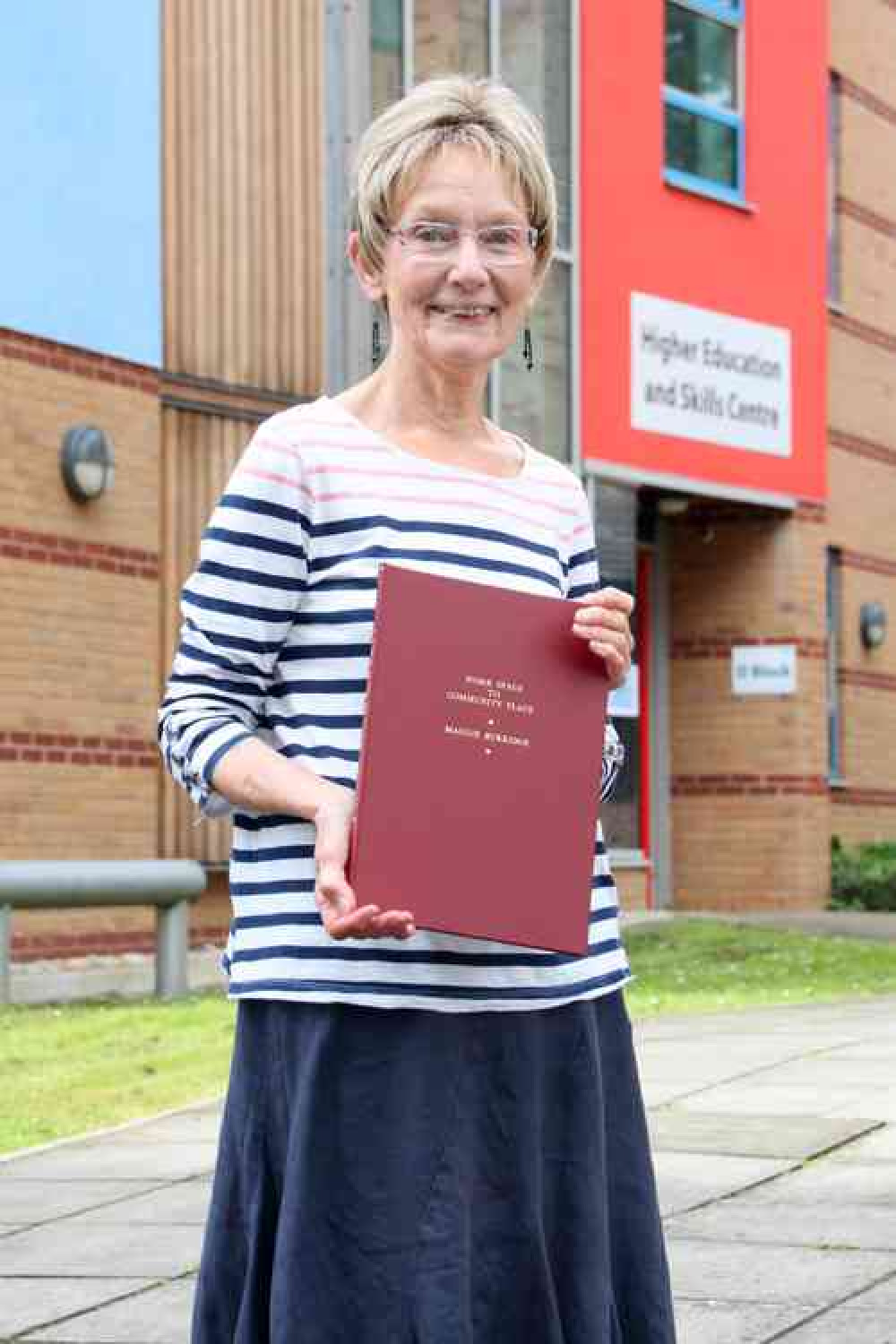 Maggie Burridge with her book produced on the history of Glastonbury's Red Brick Building