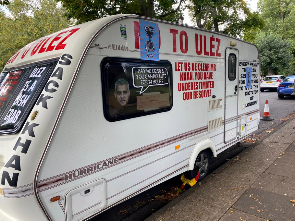 A caravan adorned with protest slogans against the ULEZ (Ultra Low Emission Zone) has been securely fastened outside the residence of Sadiq Khan (image via Jon Mills/SWNS).