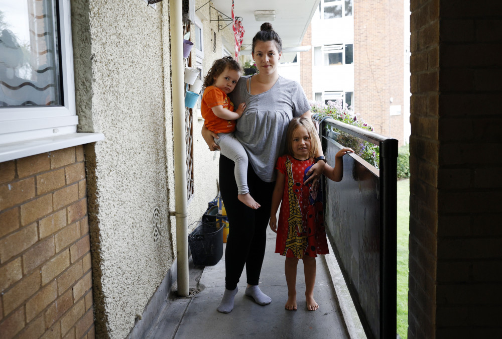 Emelye Offin, 28, with her two daughters on the Ham Close estate. Credit: Facundo Arrizabalaga/MyLondon