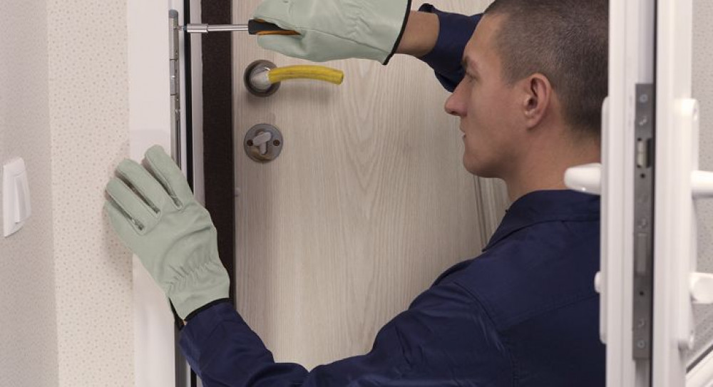 A locksmith demonstrates the installation of a high-security door lock to enhance business security.