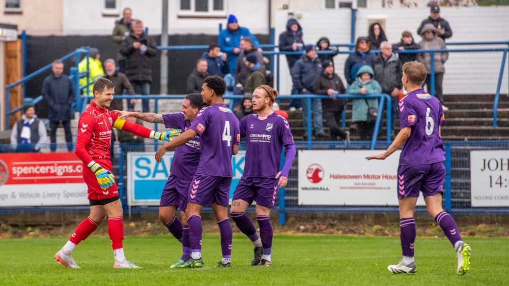 Hitchin Town teammates celebrate with Charlie Horlock after the Canaries keeper scored a goal at Halesowen Town on Saturday. CREDIT: PETER ELSE 