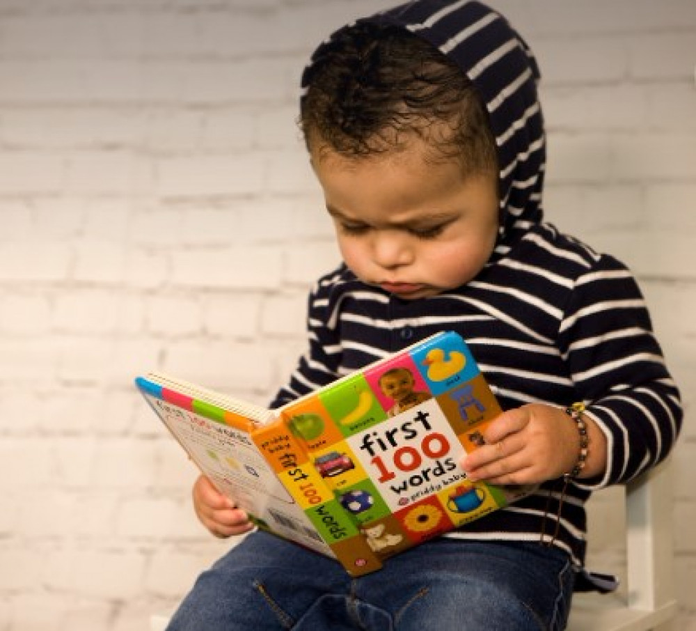 Young child with their first book. (Photo: Specsavers)