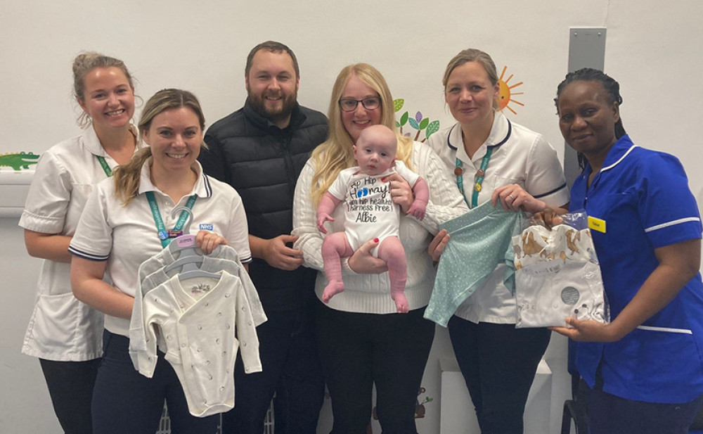 Abi and Matt, their baby Albie, and the Musculoskeletal and Orthopaedic Paediatric Physiotherapy team