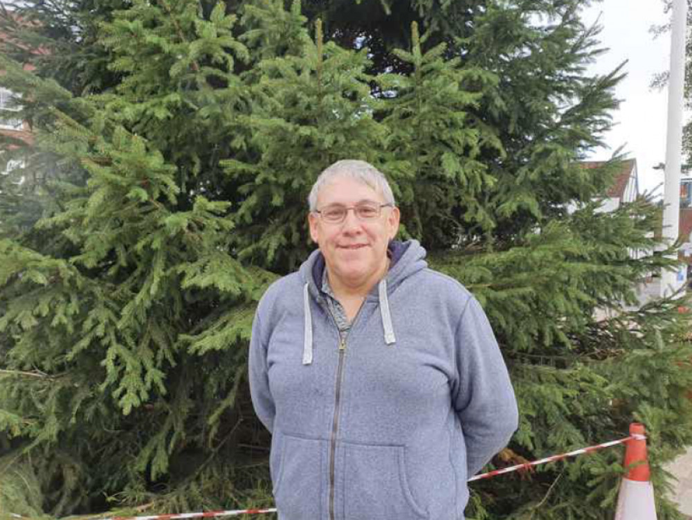 Hitchin councillor Ian Albert has awarded Hitchin Christmas Hamper team £750 from his Herts County Council locality budget to continue the great work they do in our community during the festive season. PICTURE: Ian Albert in front of the Hitchin Christmas tree. CREDIT: Hitchin Nub News 