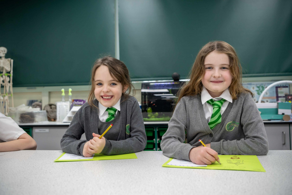 Two pupils from Catmose Primary School drawing their designs for the welcome card. Image credit: Bellway.