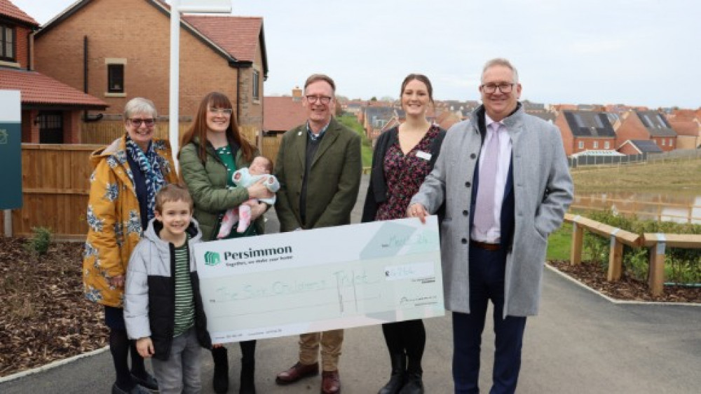 L to R Julie Kett, Receptionist and lead fundraiser, Vinnie, Beth Deacon-Bates and baby Clara, Cllr Simon Dowling, Abi Corbett, of The Sick Children's Trust, Ian Hamilton, MD of Persimmon Homes (Picture: Submitted)