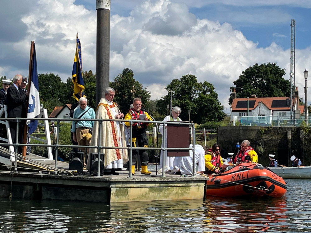 Reverend David Cloake of St Mary and St Alban reading to the crowd with RNLI crewmember Tim James. (Photo: Teddington RNLI)