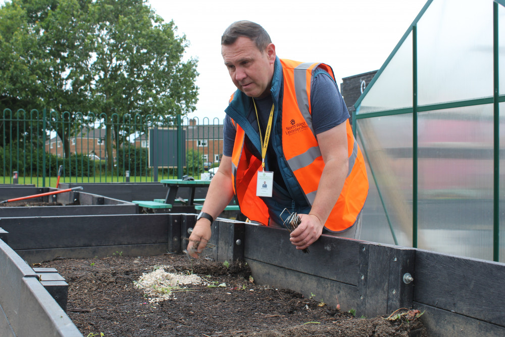 Councillor Michael Wyatt, Portfolio Holder for Communities and Climate Change helping to weed and plant at Coalville Community Garden. Photo: North West Leicestershire District Council