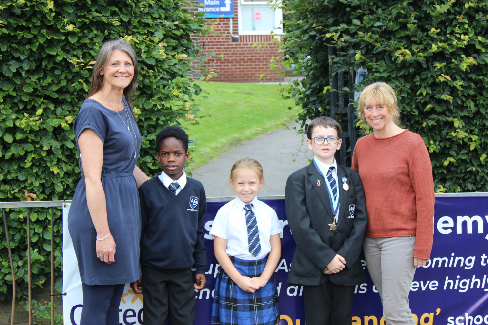 ALL SMILES AT ASH GROVE: Incoming Principal Sally Veale (left) with Outgoing Principal Judith Ceuppens and pupils. (Image - Macclesfield Nub News) 