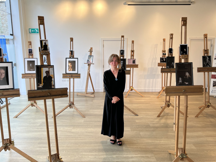 Ukrainian Photographer Viktoria Chikalo beside her works in Dickens Yard, Ealing on Friday, 16 August (credit: Moiz Saifuddin). 