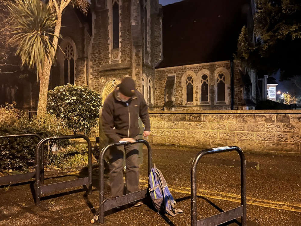 Kingston Cycling Campaign member, Roger, putting RBK's safe cycling lock stickers on bike stands (Credit Andy Allan)