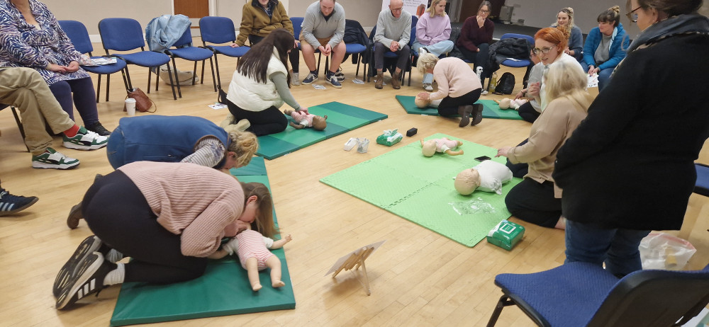 Nunney Village members practicing their newly-learned first aid techniques