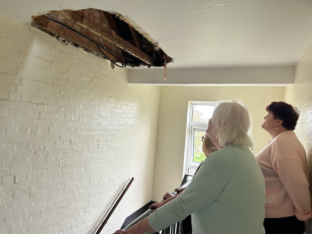 Residents looking at the partial ceiling collapse in the block on Stuart Road, Ham (pictured on 23 October). (Credit: Charlotte Lillywhite/LDRS)