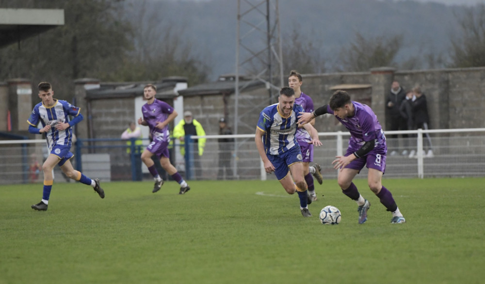 Callum Gould (No. 8 in purple) on the ball for Shepton, moments before scoring the equalising goal against Clevedon. (Colin Andrews) 