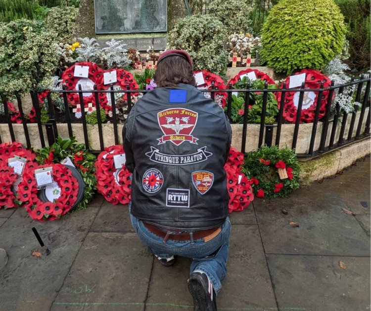 A veteran kneels at the war memorial in Glastonbury, paying tribute to those who lost their lives in conflict. (LL) 