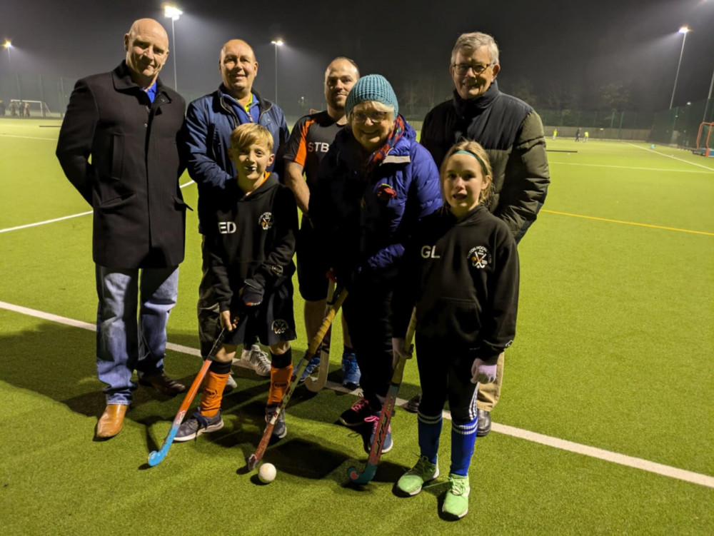 Jason Lockett (Alsager Cricket Club Gin Festival organiser), Alan Stancliffe (Alsager Cricket Club chair and gin festival organiser), Sam Tipping-Brown (Triton HC Volunteer coach) and John Poulson (treasurer of the former Alsager Partnership), junior players, Eddie and Gracie and with Suzanne Colclough (Chair Triton HC).