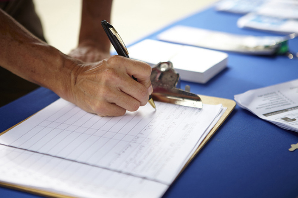 A local resident signs a petition, highlighting community concerns and the importance of public engagement.