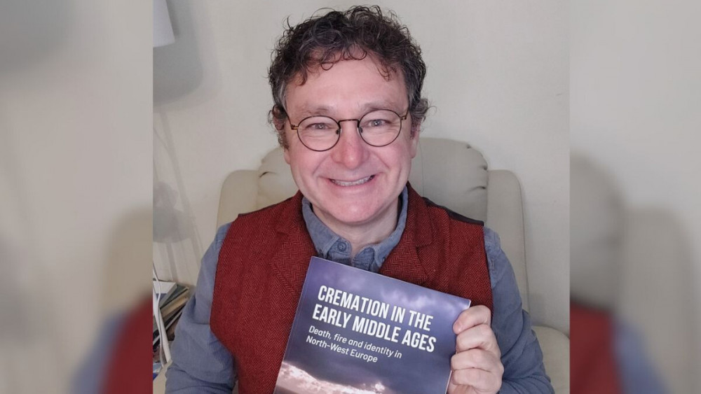 Howard Williams, Professor of Archaeology at the University of Chester, with the new publication copy of his new co-edited book (Image via: Chester University)