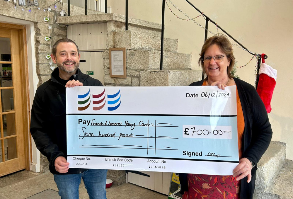 Richard Steele, operations manager at Jackson Drilling, presents a £700 cheque to Alison Adlam, chair of Friends of Somerset Young Carers, to support young carers this Christmas